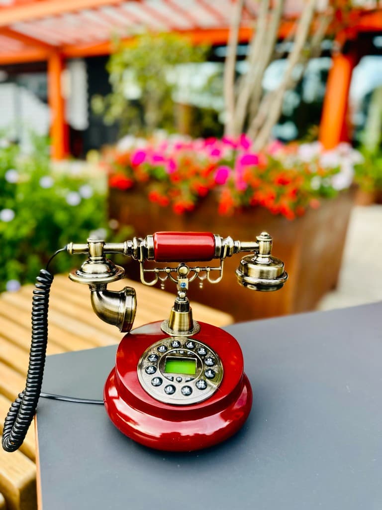 A burgundy vintage telephone on a terrace table