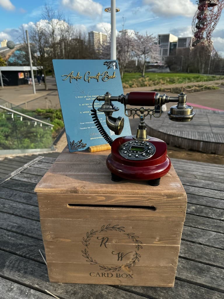 Vintage telephone on a wooden card box engraved with an RW monogram